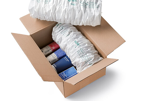 A cardboard box containing cosmetics and white paper cushioning